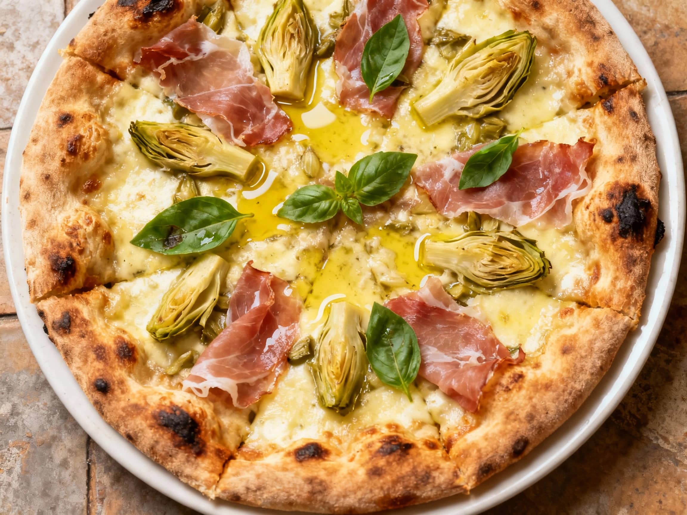 Thin, crisp Sicilian pizza topped with savory prosciutto, tender artichoke hearts, melted mozzarella cheese, and fresh basil, baked to golden perfection.