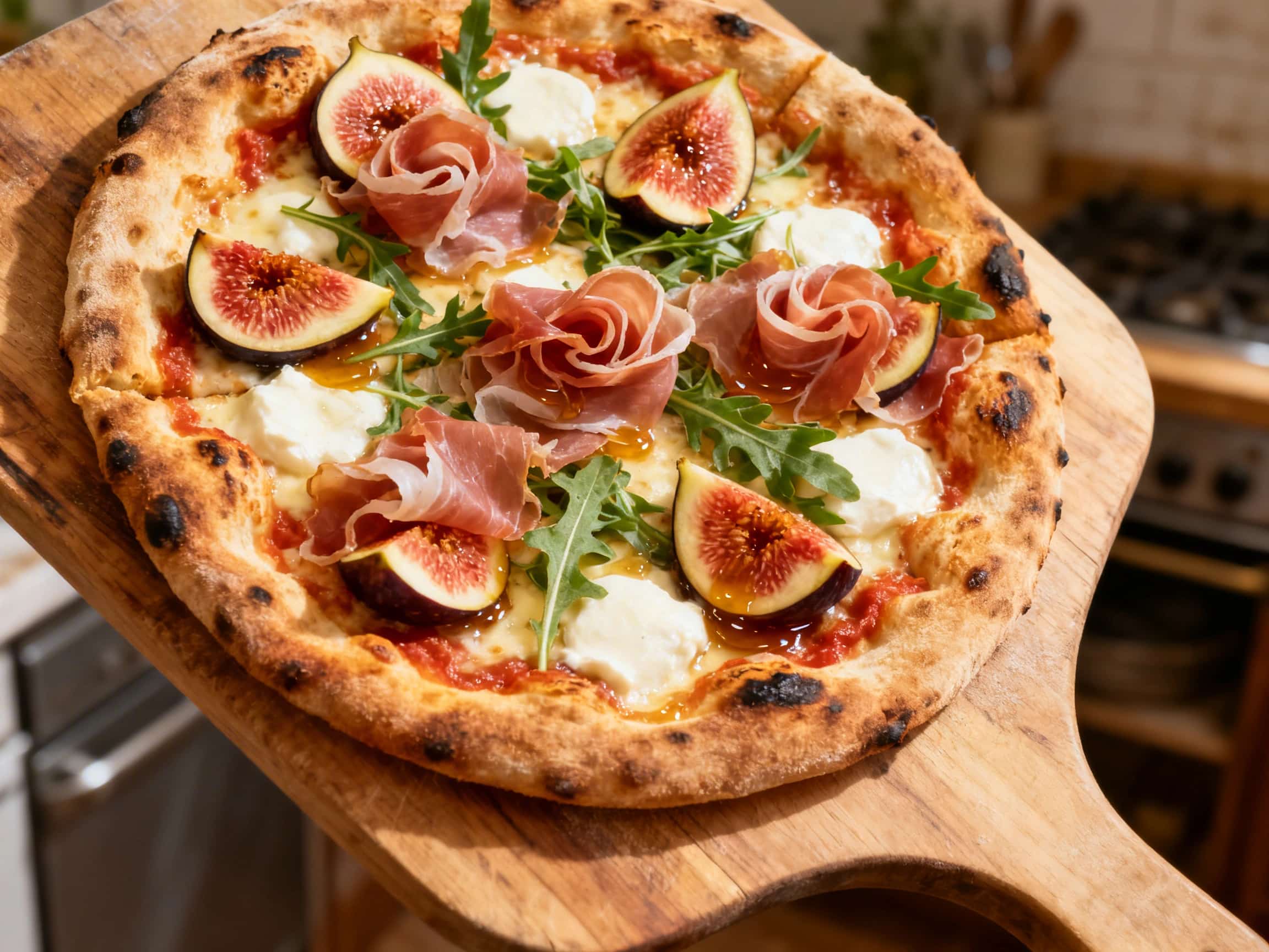 A close-up of a halved Neapolitan pizza, featuring a beautifully blistered crust. It's generously topped with vibrant green arugula, delicate pink prosciutto slices, and rich purple quarters of fresh figs. Creamy white mozzarella is visible, and a glistening balsamic glaze is drizzled over the toppings, all resting on a rustic wooden board.